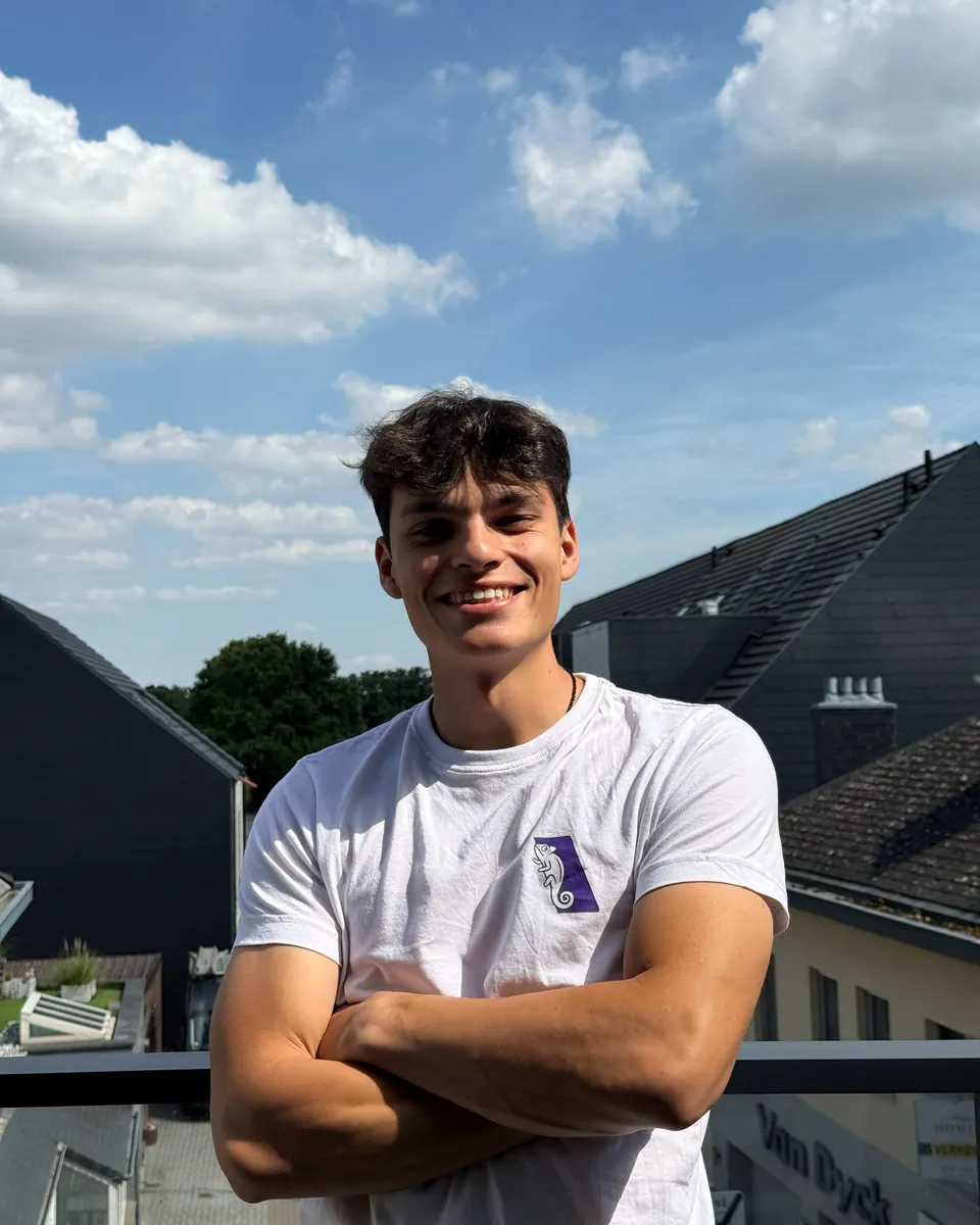 Helder lacht met gekruiste armen op een balkon